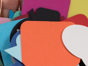 Hand holding colourful cardboard speech bubbles
