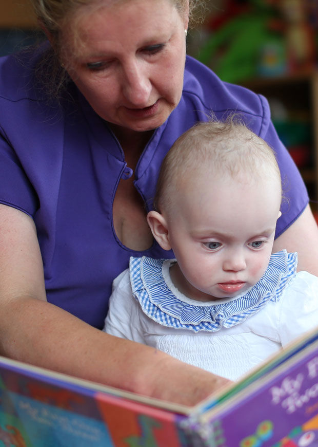 Early year educator reading to toddler