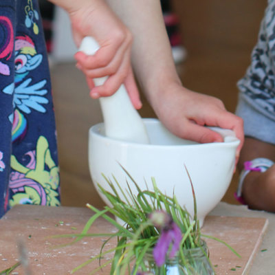 Cropped image of young girls with pestle and mortar