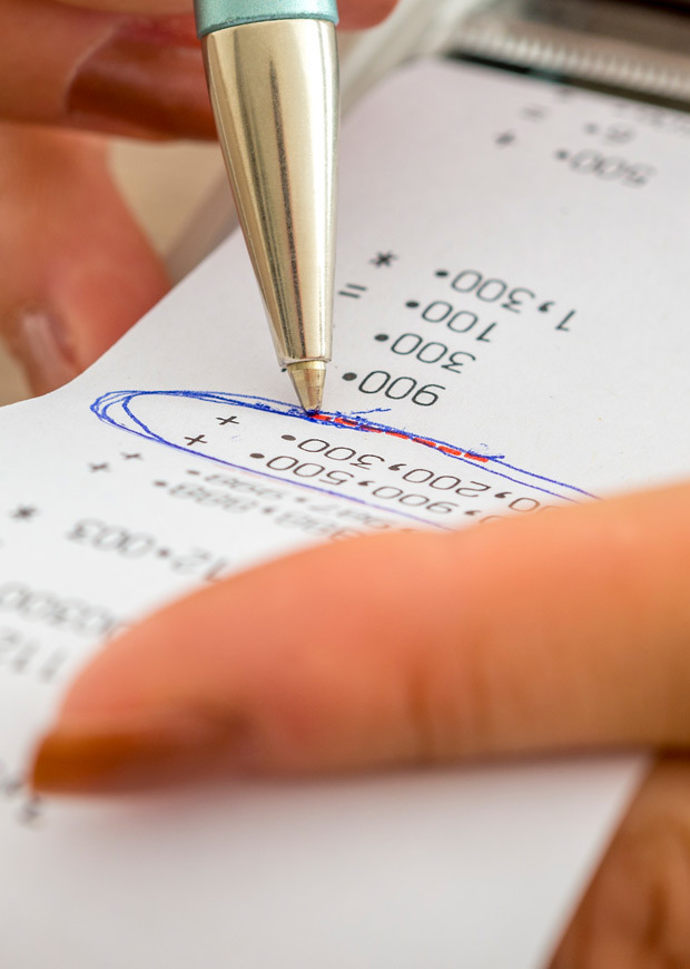 Close up image of person checking receipt printout in portrait layout