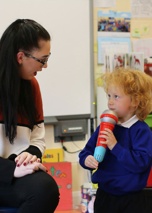 Teacher with child and plastic microphone, portrait format