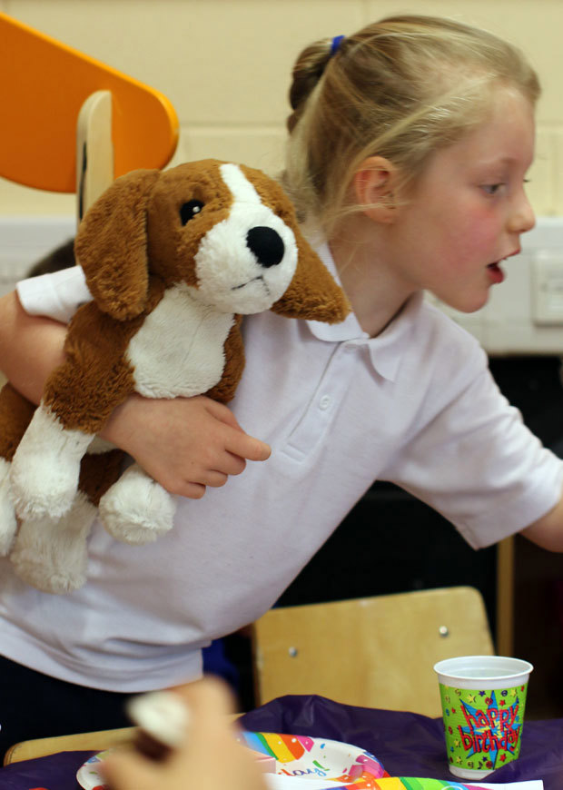 Child in classroom with teddy, portrait format