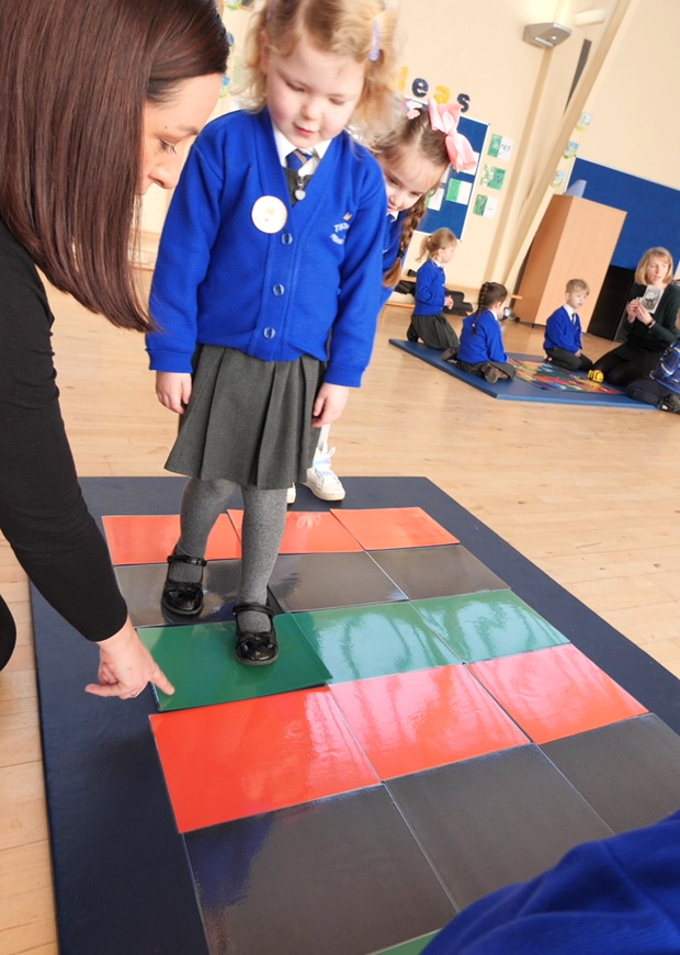Class working with Beebots in gym hall