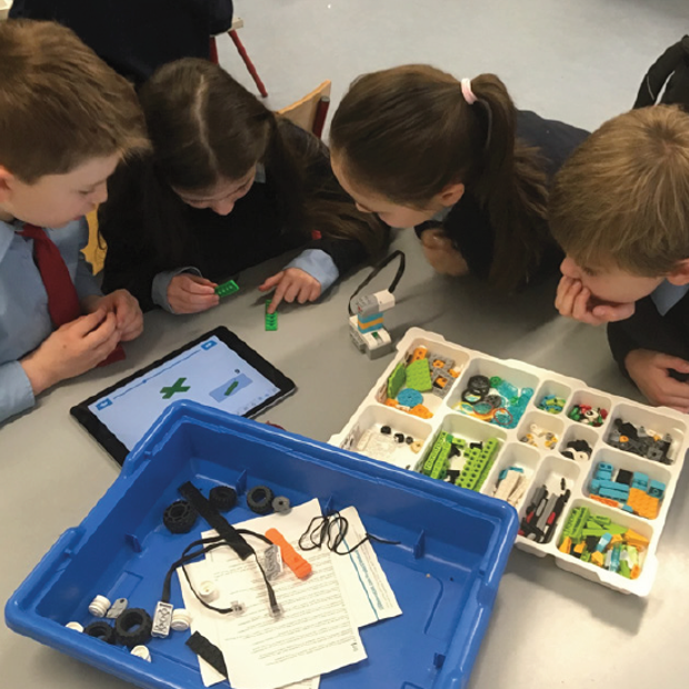 Children surrounding a Lego car and iPad