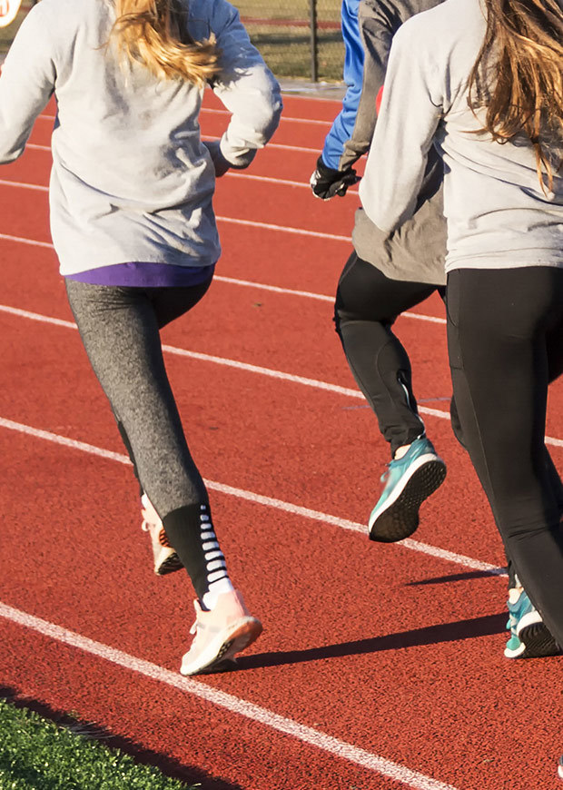 Portrait crop of students running on a race track