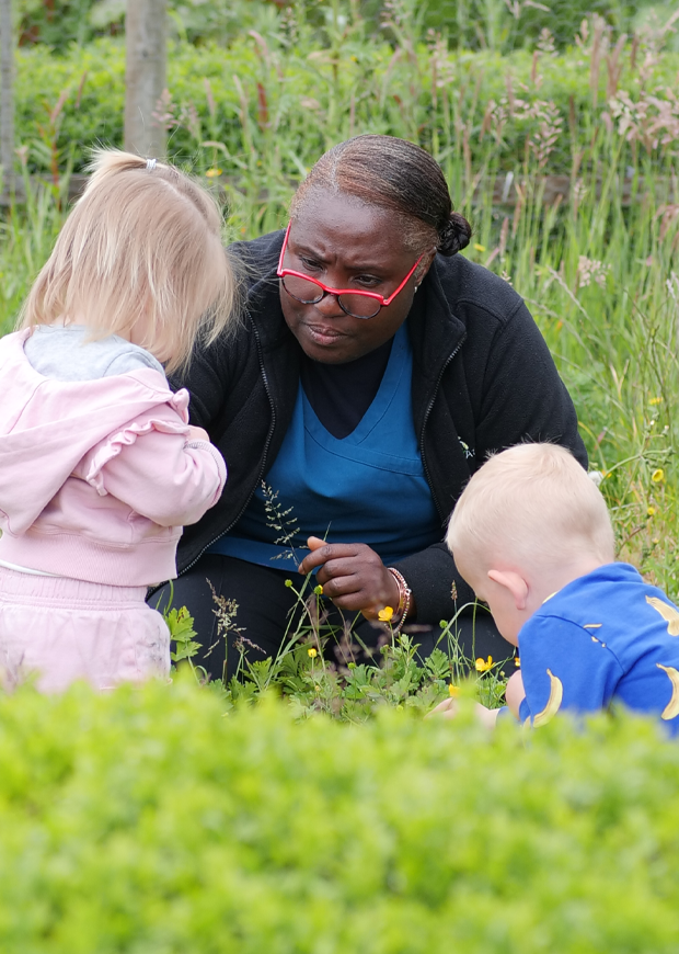 Adult in a park with two young children